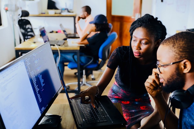 a mentor works at a computer with a student