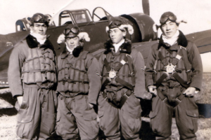 four WWII Japanese pilots pose in front of a fighter plane